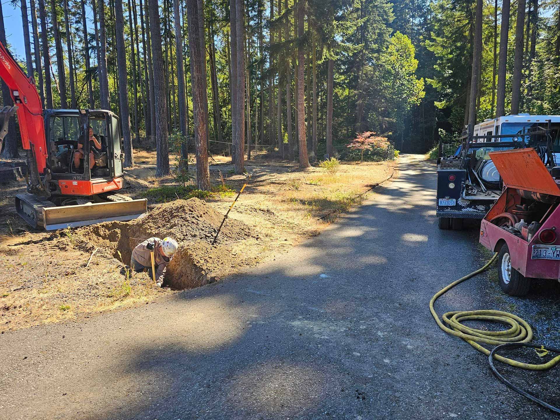 Workers from Salish Excavation and Trucking LLC digging a trench for utility installation