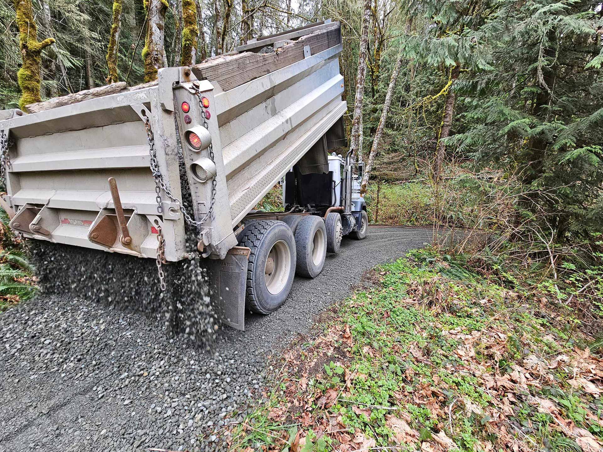 Truck dumping pile of gravel