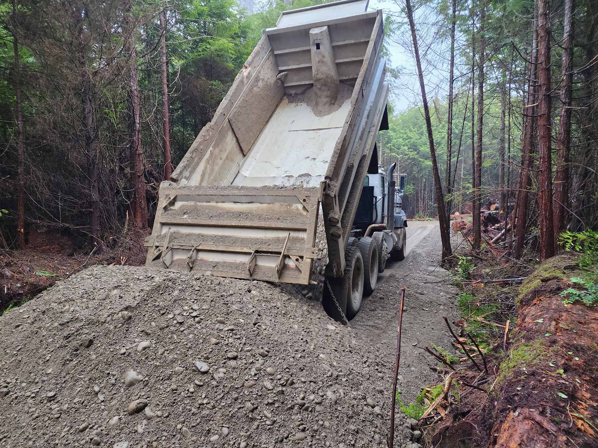 Trucking dumping pile of gravel