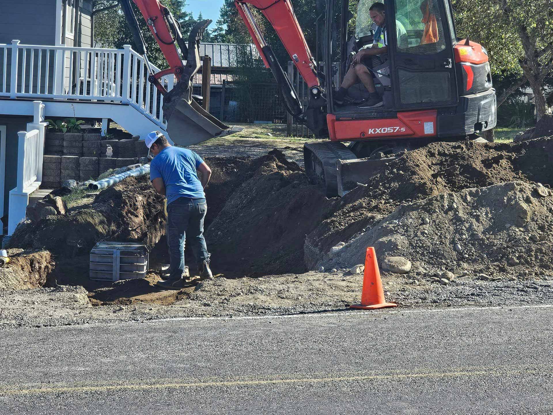 Workers digging trench outside home for utility installation