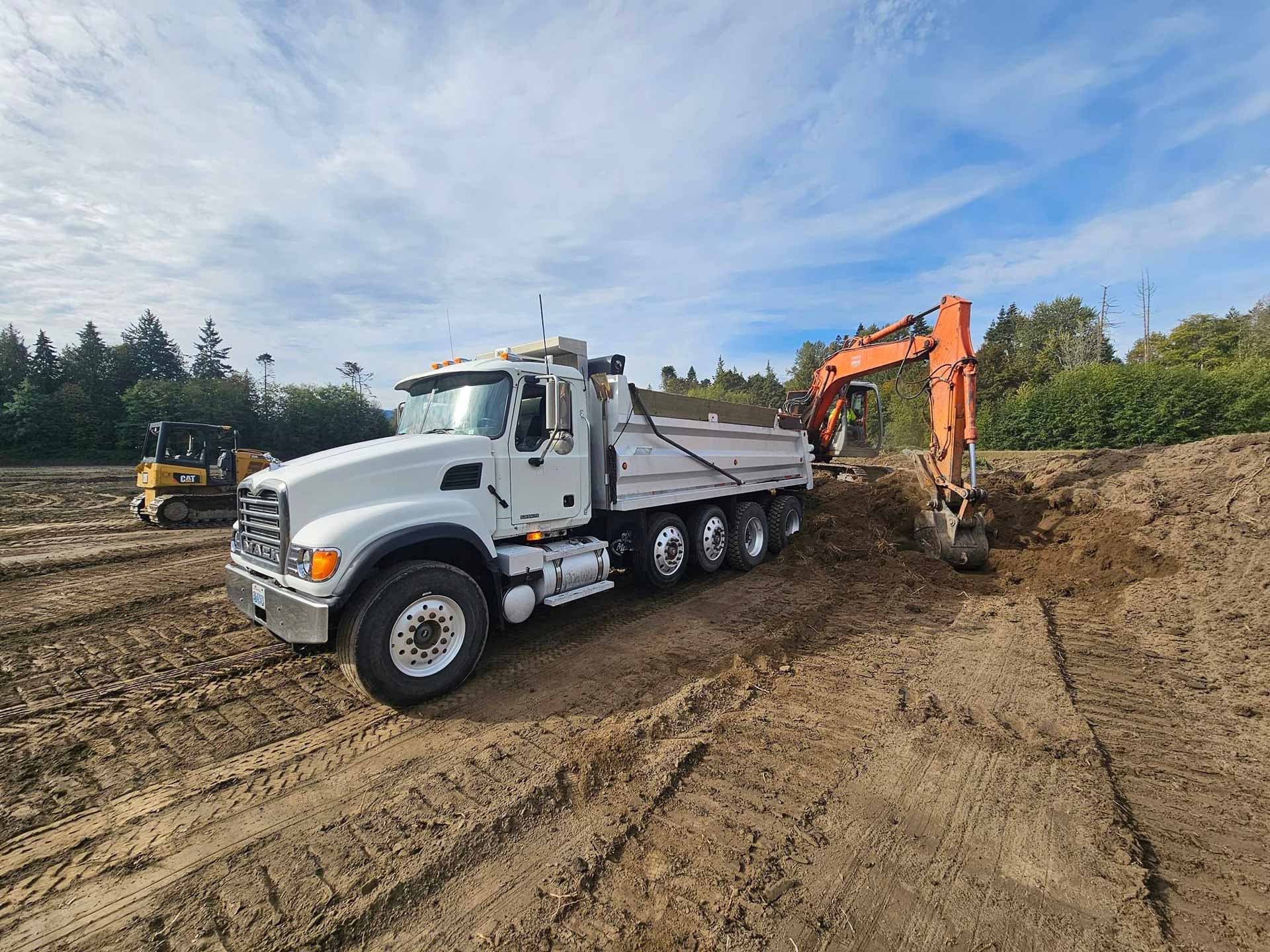 Truck dumping dirt on newly cleared lot